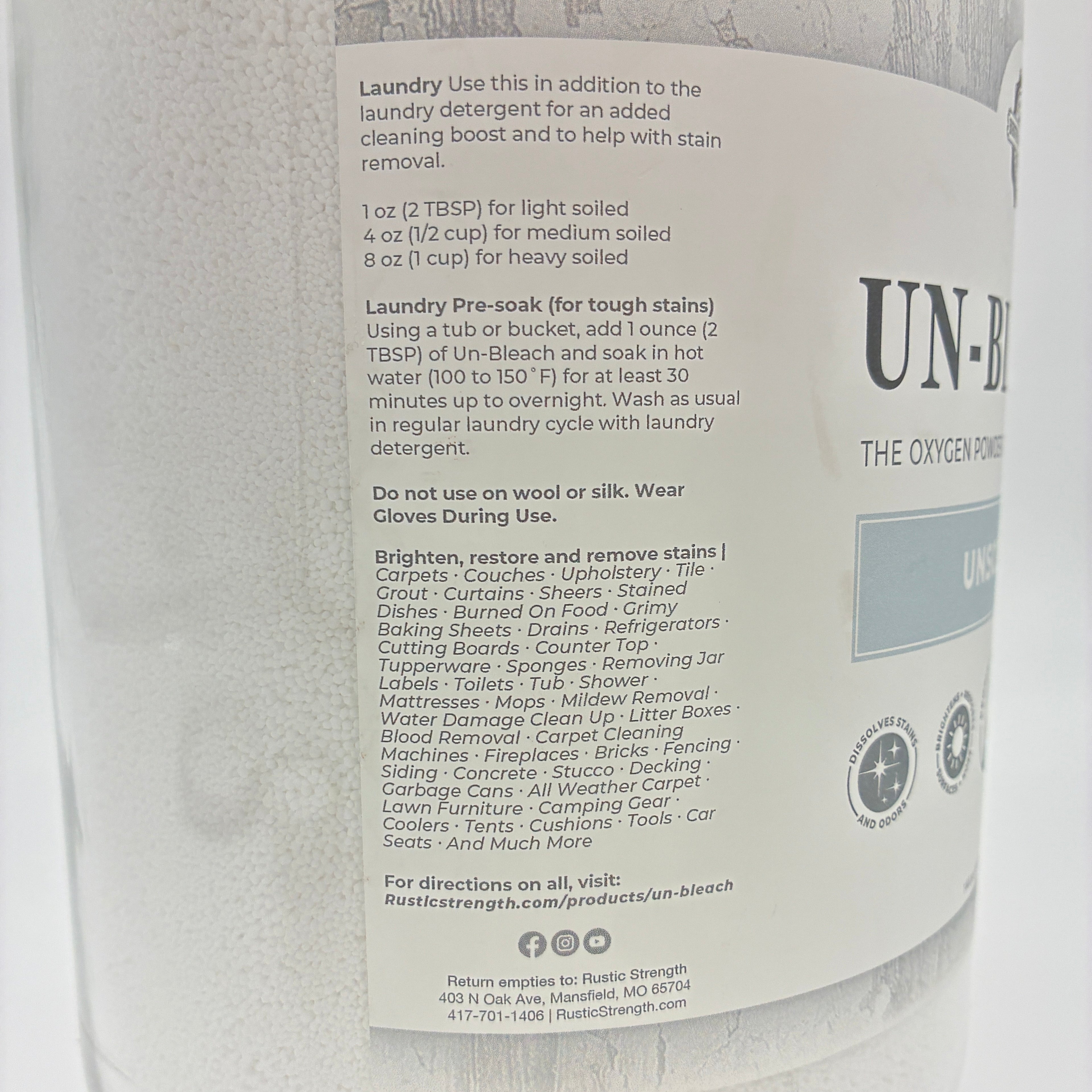 A close-up of a large white glass bottle of Unbleach laundry cleaner, showing the front label with product details and branding.